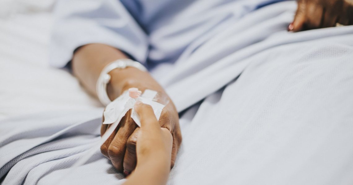 Daughter holding  her mothers hand in the hospital