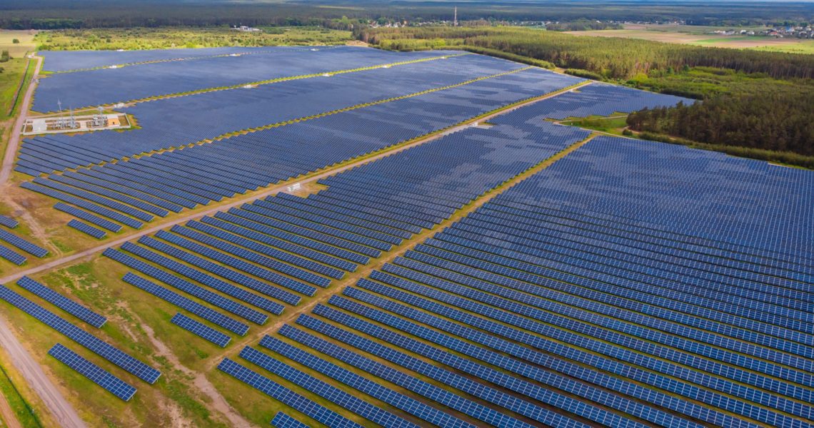 Solar panel produces green, environmentaly friendly energy from the setting sun. Aerial view from drone. Landscape picture of a solar plant that is located inside a valley
