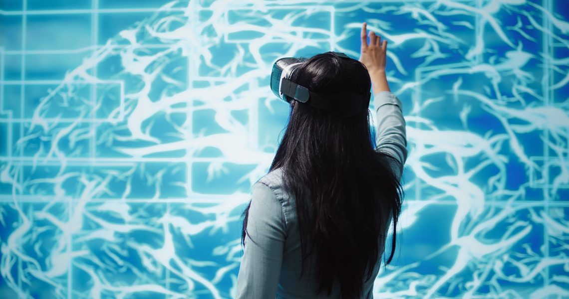 Developer wearing VR headset looking at hologram of artificial intelligence human brain simulation. Programmer interacting with AI visualization showing machine learning algorithms, camera B